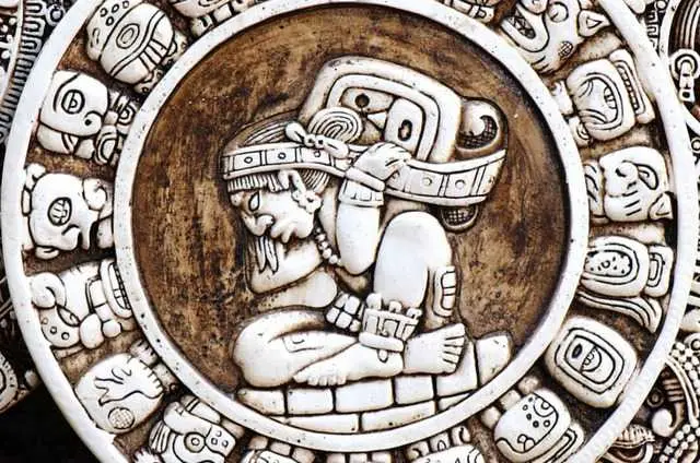 Stenen Maya-kalender met in het midden een zittende figuur, omringd door dagtekens